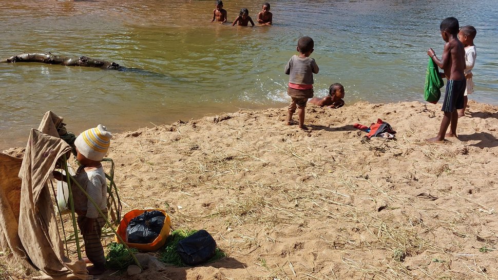 [Translate to English:] Das Foto zeigt Kinder in Madagaskar an einem Fluss spielen und baden.